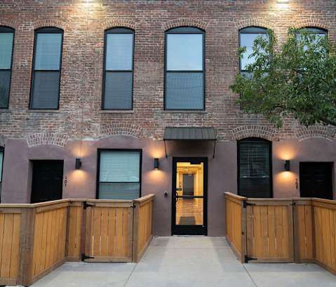 A building with a brown brick facade and a wooden fence in front.