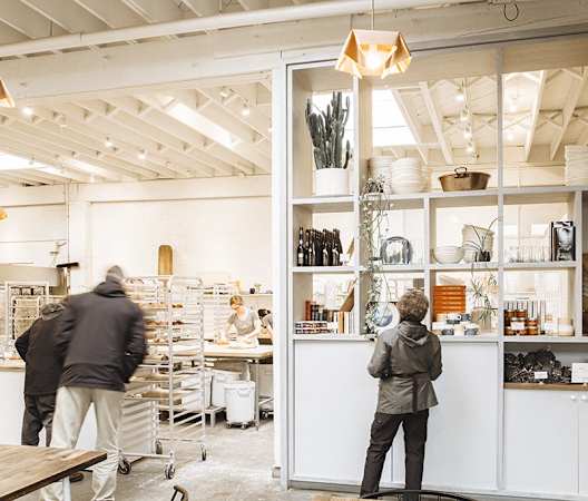 people working in a shop with white cabinets and glass doors at The Hayes on Stone Way, Seattle, WA, 98103