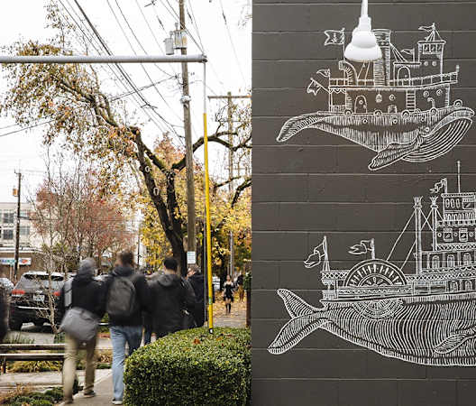 a group of people walking down a sidewalk in front of a mural of a whale at The Hayes on Stone Way, Seattle, WA, 98103