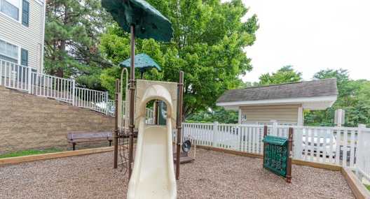A playground with a slide and a green canopy.