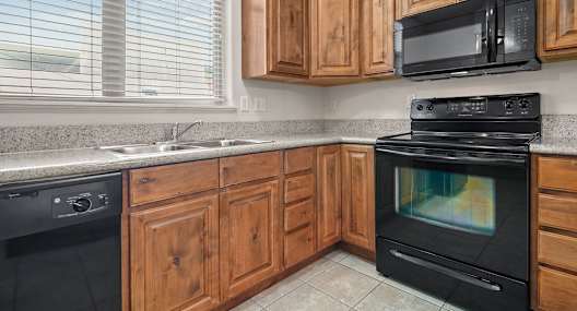 a kitchen with black appliances and wooden cabinets