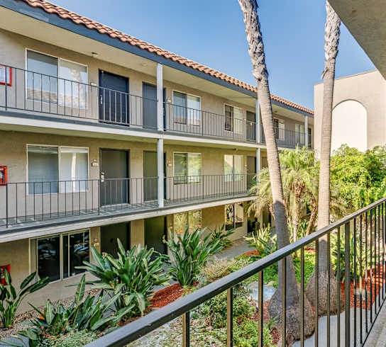 a balcony view of a building with palm trees