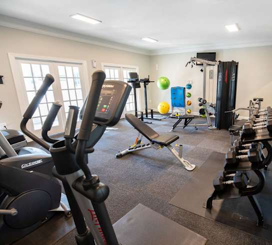 A gym with treadmills, exercise balls, and weight machines.