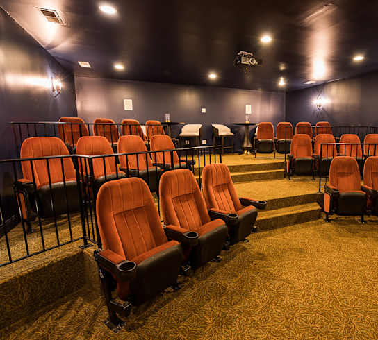 A row of orange seats in a dark room.