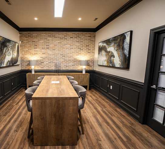 A conference room with a long table and chairs.