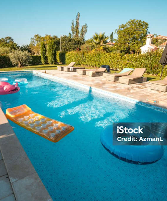 Community pool with lounge furniture and pool toys