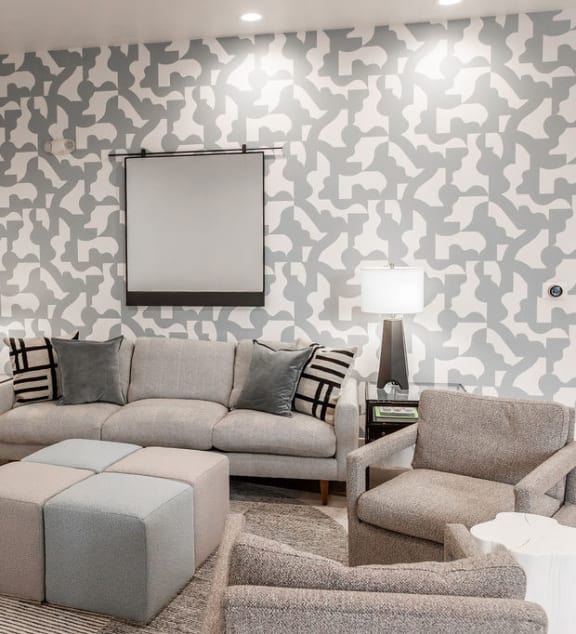 a living room with a couch and chairs and a wall of wallpaper