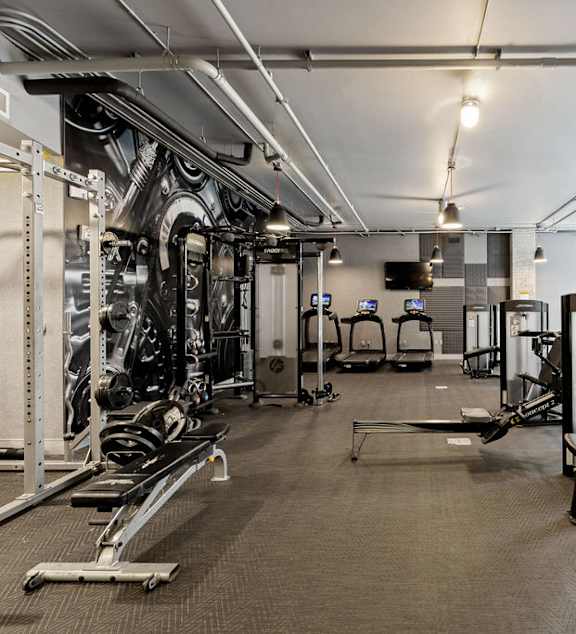 A gym with a variety of equipment including a leg press machine.