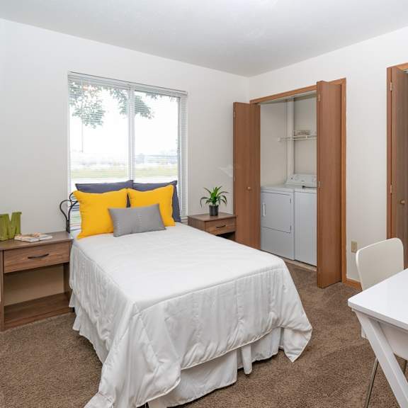 a white bedroom with a large bed and a window
