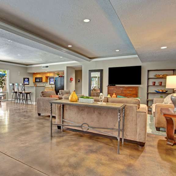 A living room with couches and chairs and a table at Bridges Apartment Homes