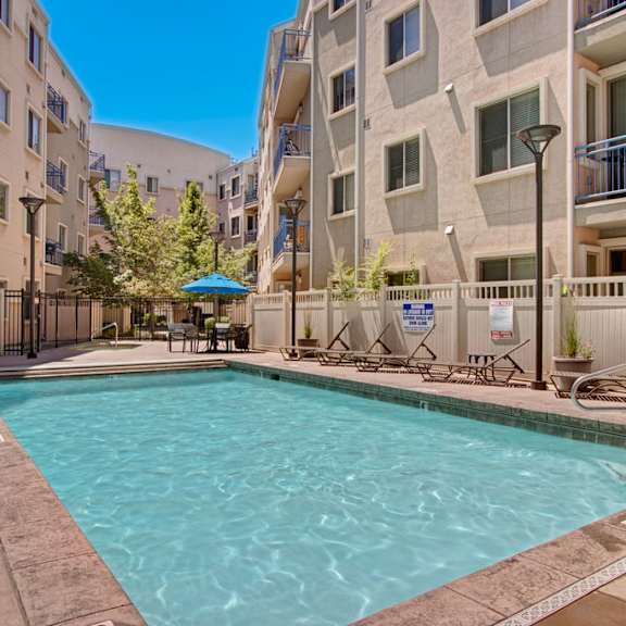 A swimming pool and a patio at Bridges Apartment Homes. 