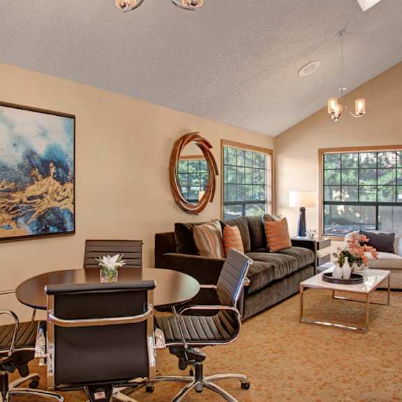 The conference room with a table and chairs, decorations, a couch, a plush chair, and a coffee table at Grand View. 