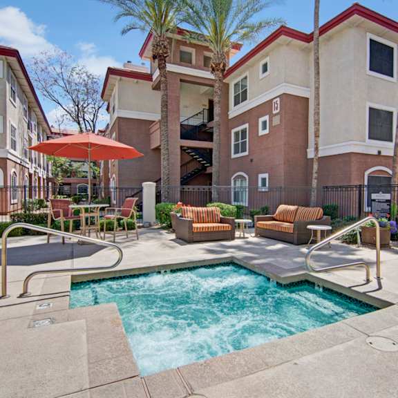 The hot tub at Mozaic at Steele Park with chairs and tables nearby. 