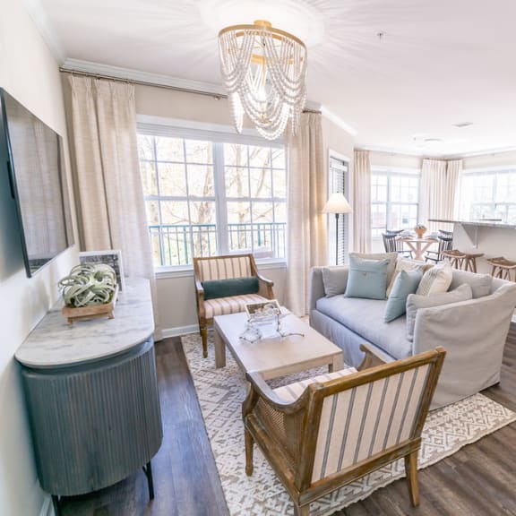 a table with a vase and a painting on it next to a window at The Ledges Apartment Homes, Connecticut