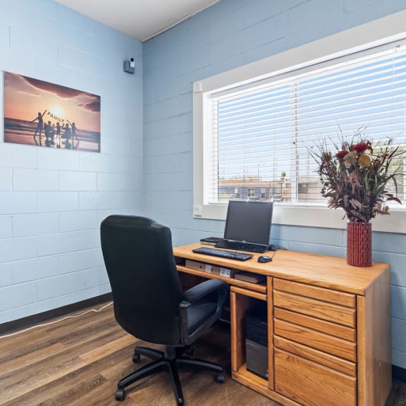 an office with a computer and a vase of flowers