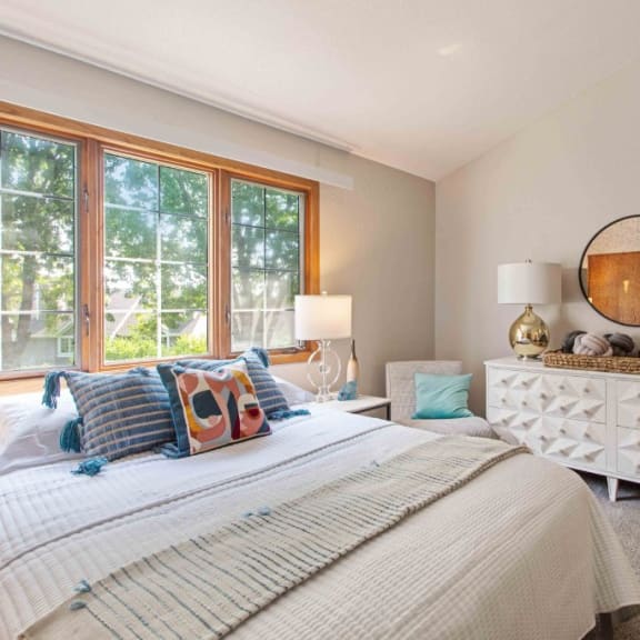 a bedroom with a bed and a large window at Seasons Villas, Woodbury Minnesota