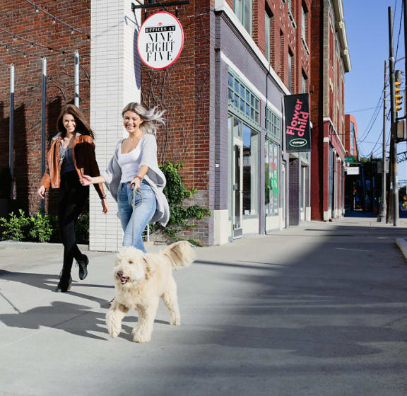 two girls walking their dog in front of the pet friendly 985 high in the short north