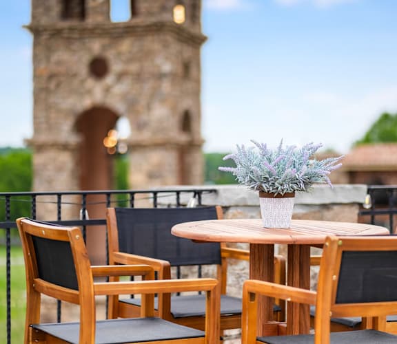 a table with a vase of flowers on a balcony