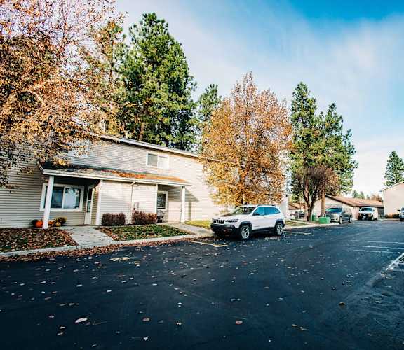 a suburban street with a car parked in front of a house