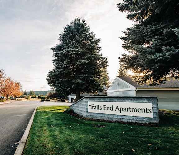 a sign that reads trails end apartments on the side of a road