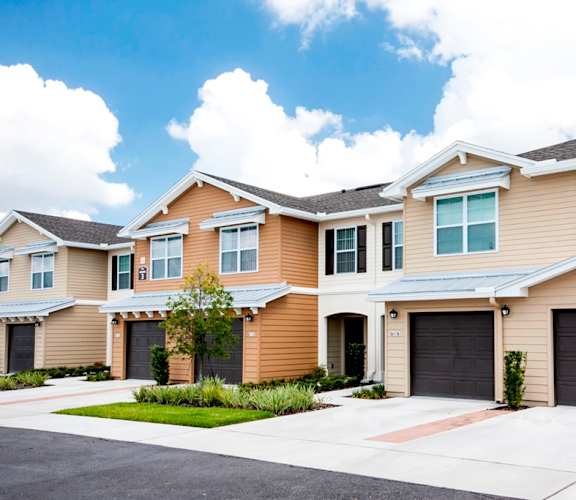 a house with two garages and two cars in front of it