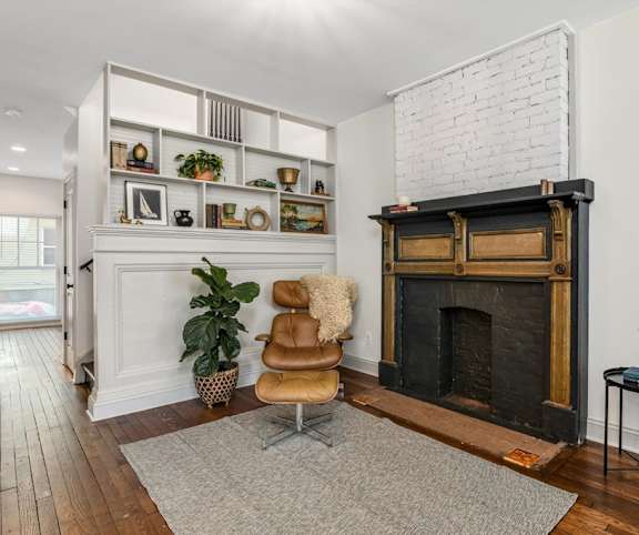 A living room with a fireplace and a chair.
