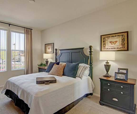 A bedroom with a large bed and two night stands with lamps at Bela Rosa Apartments. 
