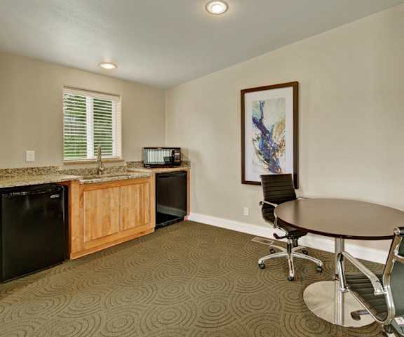 The resident lounge with a table, chairs, kitchenette with a microwave, dishwasher, and sink at Four Seasons. 