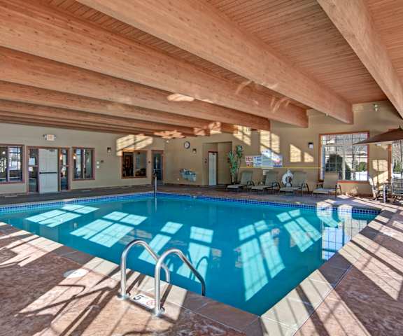 The indoor pool with tables and chairs at Grand River Estates. 