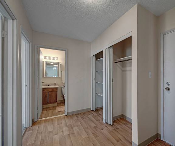 The hallway with a view of the bathroom, closet, and doorway of an apartment at Cedar Gardens Apartments. 