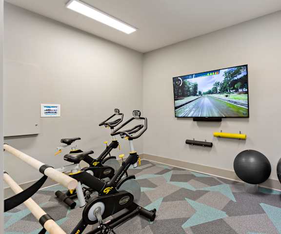a gym with exercise equipment and a tv on the wall at Sonterra Apartment Homes, Texas, 78726