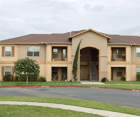 an apartment building with a sidewalk in front of it
