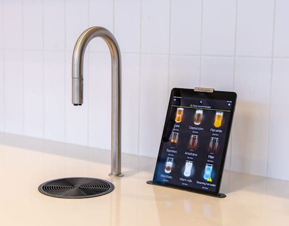 a tablet on a kitchen counter next to a faucet