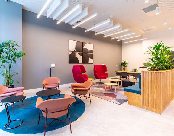 a lobby with chairs and tables and a reception desk