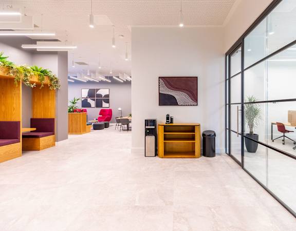 a lobby with glass doors and a table with a cabinet