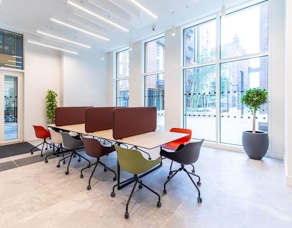 a large table with chairs in a room with windows