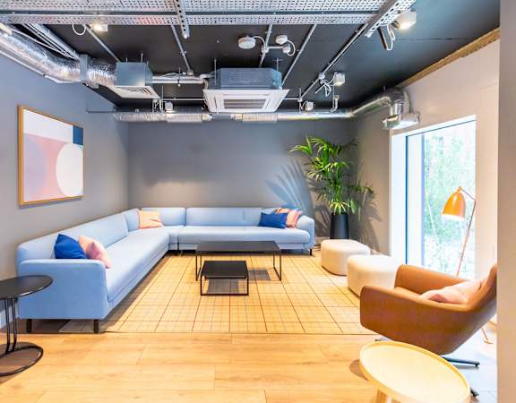 a living room with blue couches and chairs and a table