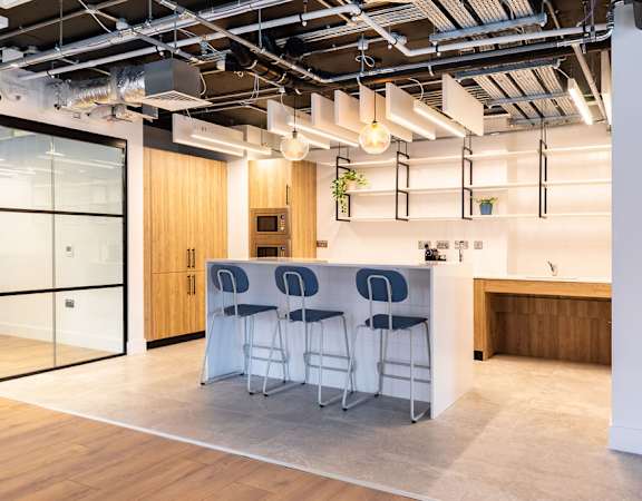 a kitchen with a table and chairs in a room with glass doors