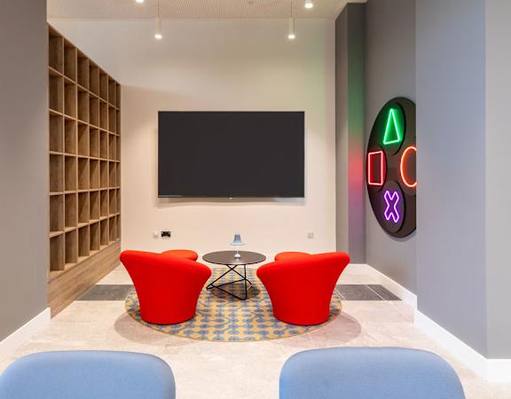 a room with chairs and a table and a television