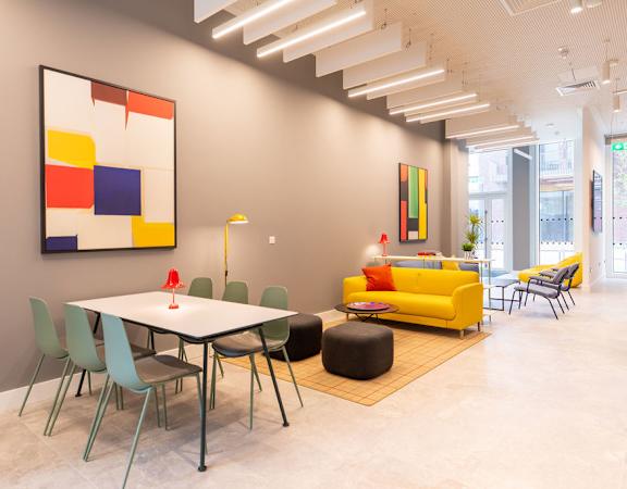 a dining room with a table and chairs and a painting on the wall