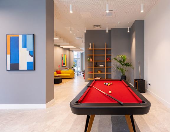 a pool table in a living room with a painting