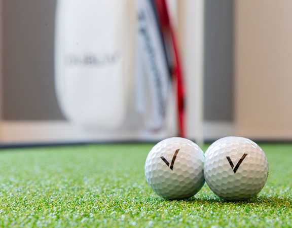 two golf balls sitting next to each other on the grass