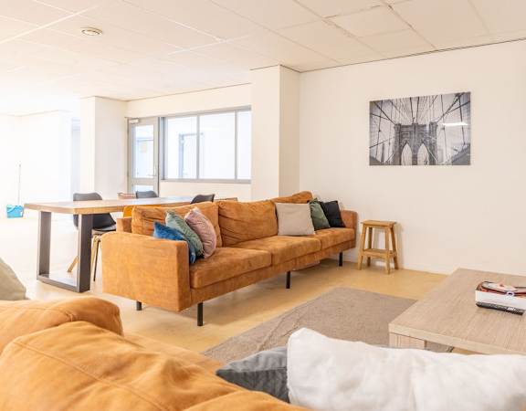 A living room with a yellow couch and a television.