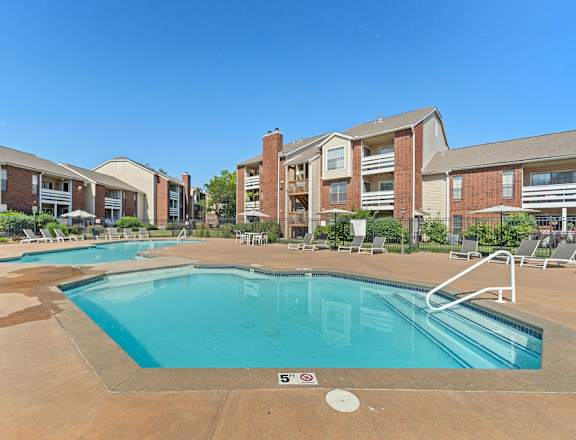 A swimming pool in front of apartment buildings.