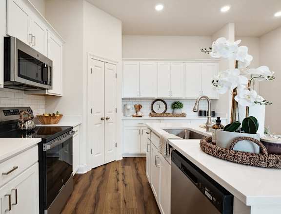 a kitchen with white cabinets and stainless steel appliances
