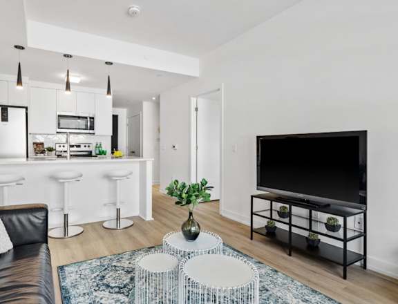 A modern living room with a black leather couch and a white coffee table.