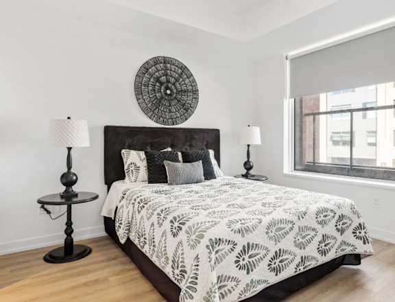 A bedroom with a large bed and a round decorative piece on the wall.