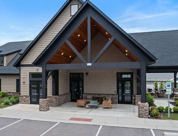 A modern building with a large front porch and a stone pillar.