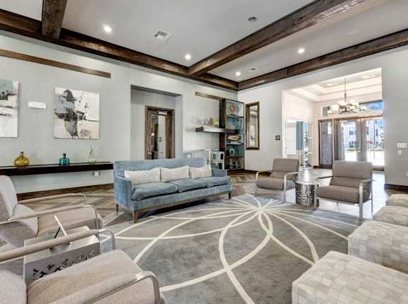A living room with a grey couch and a grey rug.