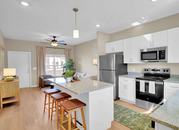 A kitchen with a refrigerator, oven, and microwave.